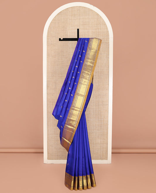 Blue Kanchipuram Silk Saree, Gleamed Up with Zari Buttas on Its Body, Complemented by a Contrast One-Sided Border of Paneer Sombu, Banaras, and Jaal Designs, Pallu of Floral Designs, and Comes Without a Blouse