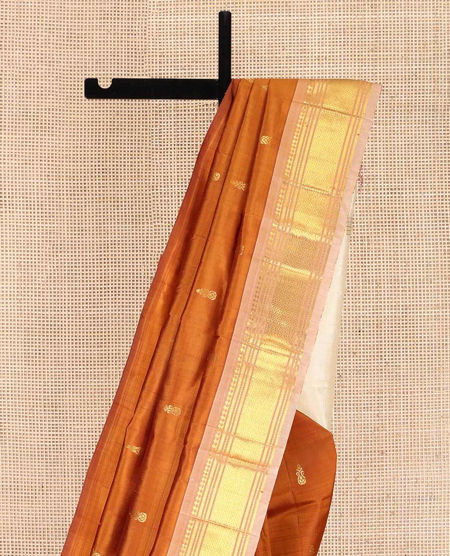 Rust Orange Kanchipuram Silk Saree, Bedecked with Zari Buttas on Its Body, Complemented by a Contrast One-Sided Border of Panner Sombu, Banaras, Muthu, and Mayil Kann Designs, Pallu of Zari Designs, and Comes Without a Blouse