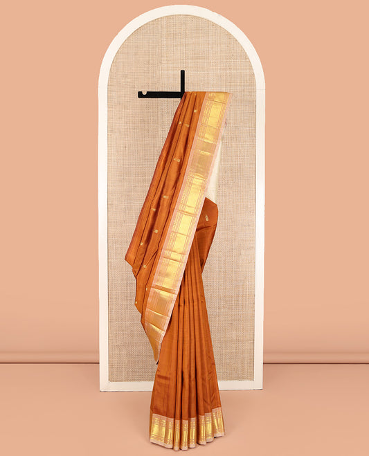 Rust Orange Kanchipuram Silk Saree, Bedecked with Zari Buttas on Its Body, Complemented by a Contrast One-Sided Border of Panner Sombu, Banaras, Muthu, and Mayil Kann Designs, Pallu of Zari Designs, and Comes Without a Blouse