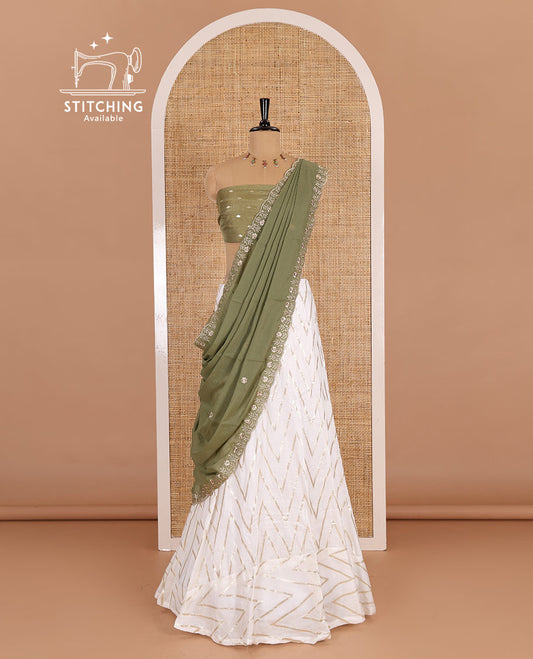 Cream-pista green half-saree, gold chevron striped nylon viscose crepe skirt, contrast diamond buttas blouse, and  a contrast scallop floral-theme embroidered dhavani