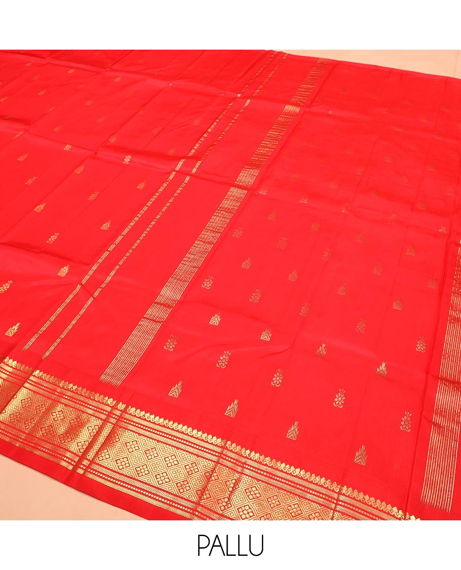 Red Kanchipuram Silk Saree Spotlighted with Zari Buttas All Over Its Body, Highlighted by Zari One-sided Border Featuring Thilakam Mokku, Banaras, Muthu, and Jaal Designs, Zari Design Pallu, and Comes Without a Blouse
