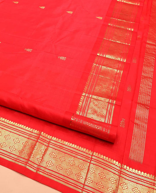 Red Kanchipuram Silk Saree Spotlighted with Zari Buttas All Over Its Body, Highlighted by Zari One-sided Border Featuring Thilakam Mokku, Banaras, Muthu, and Jaal Designs, Zari Design Pallu, and Comes Without a Blouse