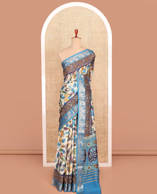 Cream and Blue Semi-Tussar Saree Enthralled with Colorful Floral Vine Print, Complemented by a Contrast Zari Border, Pallu Featuring Ikkat Design Print, and Paired with a Contrast Blouse