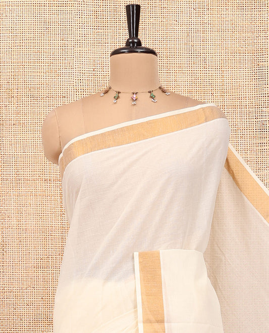 Cream Plain Kerala Cotton Saree, a Subtle Bavanji Border, Gleaming Zari Pallu, and Is Paired with a Matching Blouse