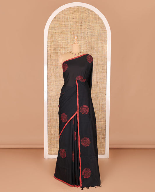 Borderless black rangoli-style chakram motifs printed South cotton saree with a matching blouse, and a contrast floral printed blouse