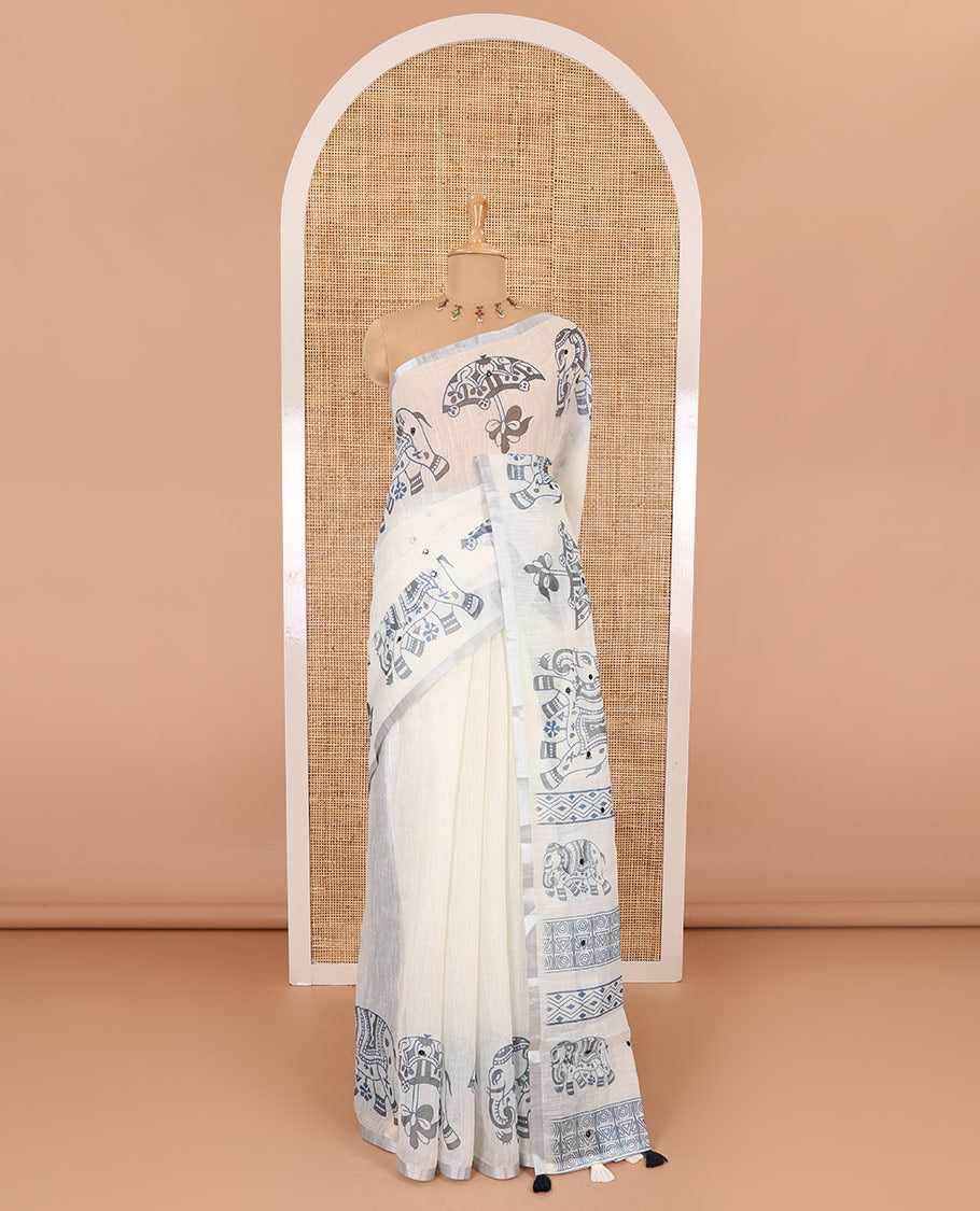 Cream mirror work linen cotton saree, zari border of umbrella and elephant motifs print, pallu of print and mirrorwork, and a contrast printed blouse