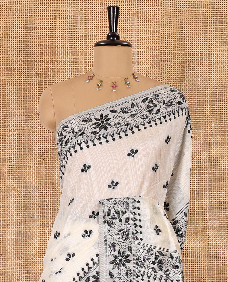 Half-white and black floral thread buttas woven jute cotton saree, floral thread weave border, floral-paisley weave pallu, and a matching blouse