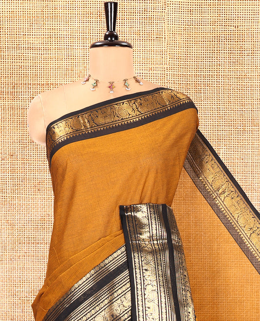 Mustard Plain Chettinad Cotton Saree, Complemented by a Contrast Rettai Pettu Temple Sliver-Sheen-Gold Zari Border of Coin, Elephant, and Peacock Designs, Subtly Striped Pallu, and Paired with a Matching Blouse