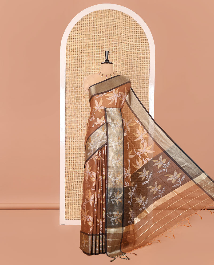 Brown Chanderi Cotton Saree, Prettified with Leaf Motifs on Its Body, Complemented by a Contrast Border of Leaf Designs, Pallu Steeped with Colorful Floral Designs, and Paired with a Contrast Blouse