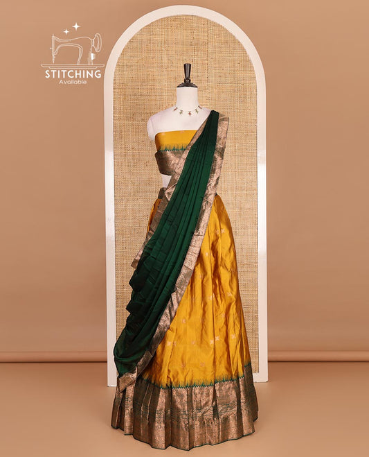 Mustard taffeta silk half saree, zari buttas with contrast green traditional zari border skirt, matching zari design blouse, and contrast plain zari border syska georgette dhavani