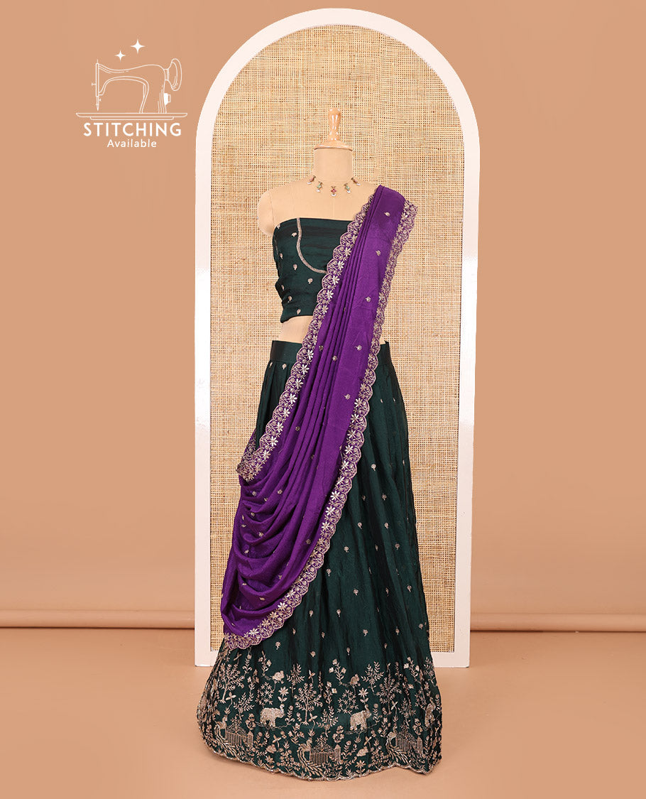 Bottle green half-saree, buttas and flora-fauna embroidered bordered velvet organza skirt, a matching velvet organza blouse, and a contrast embroidered scallop syska georgette dhavani