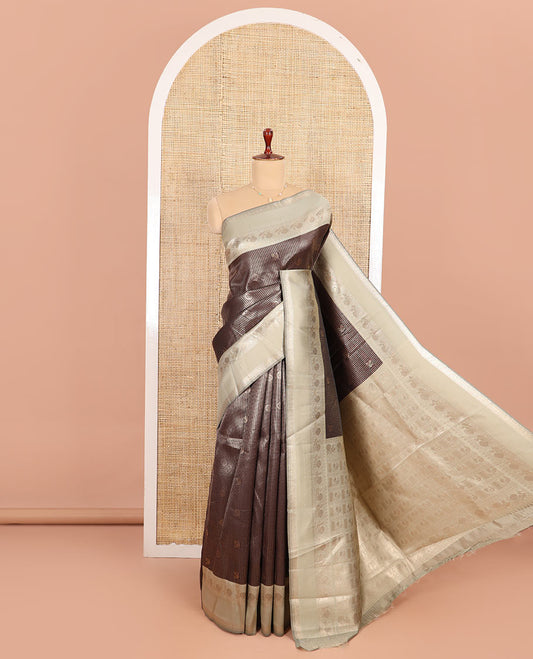 Coffee Brown Litchi Saree Decorated with Peacock Chakram Butta Enclosed Zari Checks, Complemented by a Contrast Rettai Pettu Border of Peacock Designs, Intricately Woven Pallu Steeped with Peacock Designs, and Paired with a Contrast Blouse