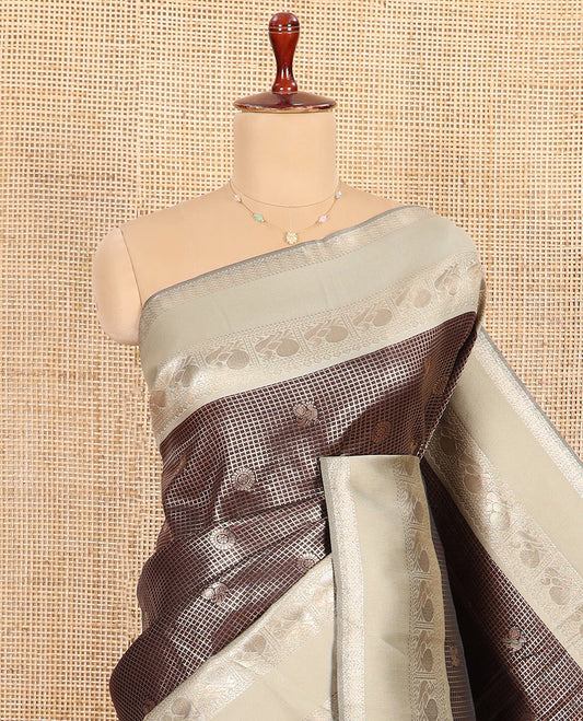 Coffee Brown Litchi Saree Decorated with Peacock Chakram Butta Enclosed Zari Checks, Complemented by a Contrast Rettai Pettu Border of Peacock Designs, Intricately Woven Pallu Steeped with Peacock Designs, and Paired with a Contrast Blouse