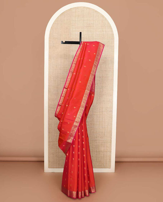 Orange floral buttas Vasundhara silk mix saree, contrast border of thilakam, muthu, cross kamalam, and kodi visiry designs, and ogee patterned pallu