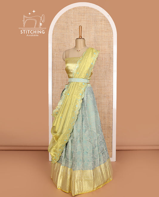 Pastel green art silk half-saree, floral vine with contrast traditional border skirt, brocade blouse, scallop embroidered dhavani, and detachable belt