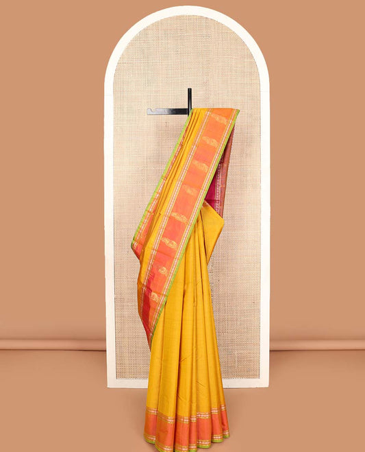 Yellow plain Kanchipuram silk saree, contrast border of rekku, muthu, rudraksham, and mayil designs, and zari striped pallu