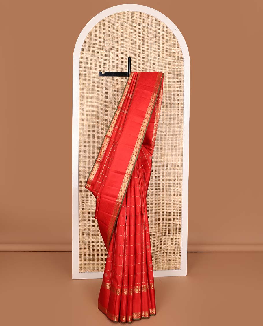 Red kolam buttas enclosed neli checked Kanchipuram silk saree, zari border of thilakam, kathir, and rudraksham designs, and pallu of neli, Greek key, yaanai, and mayil design