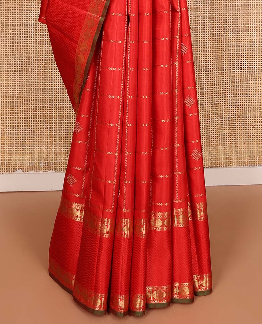 Red kolam buttas enclosed neli checked Kanchipuram silk saree, zari border of thilakam, kathir, and rudraksham designs, and pallu of neli, Greek key, yaanai, and mayil design