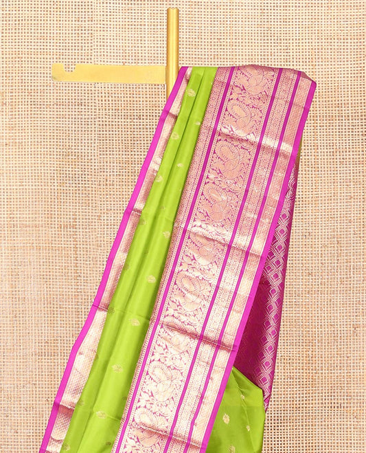 Parrot Green Vasundhara Silk Saree Ornamented with Zari Buttas All Over Its Body, Highlighted by a Contrast Border of Rekku, Muthu, Mayil, Banaras, and Mayil Kann Designs, Grand Pallu of Jaal Design, and Paired with a Contrast Blouse