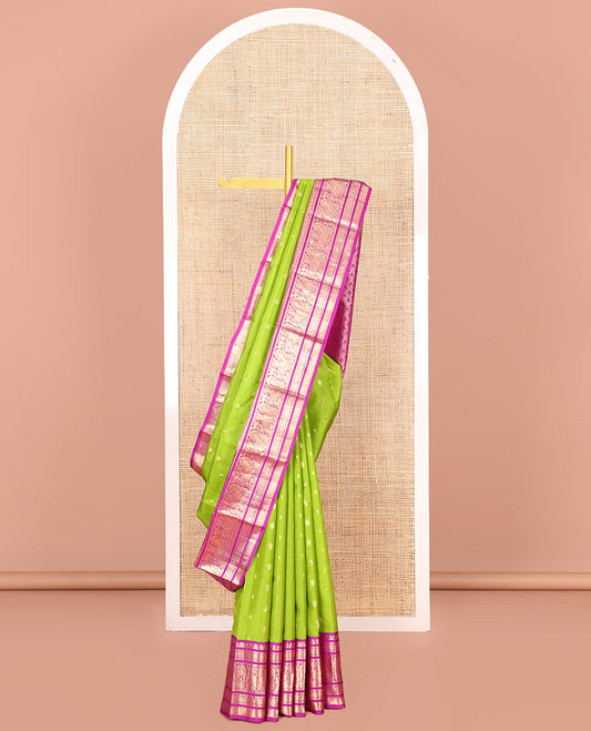 Parrot Green Vasundhara Silk Saree Ornamented with Zari Buttas All Over Its Body, Highlighted by a Contrast Border of Rekku, Muthu, Mayil, Banaras, and Mayil Kann Designs, Grand Pallu of Jaal Design, and Paired with a Contrast Blouse