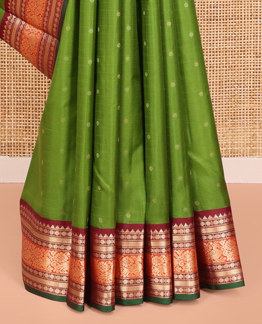 Green Vasundhara Silk Saree, Sparsely Woven with Zari Buttas All Over Its Body, Complemented by a Contrast Border of Rekku, Poun, Kathir, and Mayil Designs, Pallu Steeped with the Same Border Designs, and Paired with a Contrast Blouse