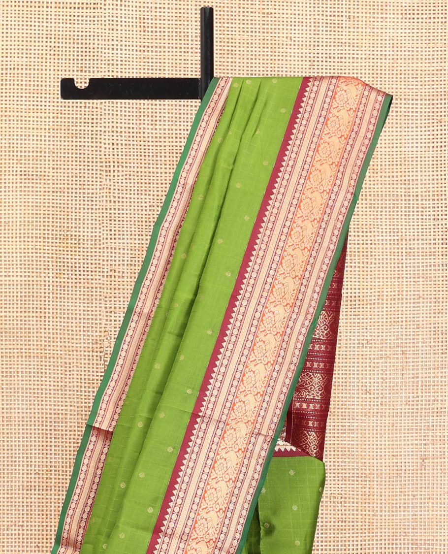 Green Vasundhara Silk Saree, Sparsely Woven with Zari Buttas All Over Its Body, Complemented by a Contrast Border of Rekku, Poun, Kathir, and Mayil Designs, Pallu Steeped with the Same Border Designs, and Paired with a Contrast Blouse