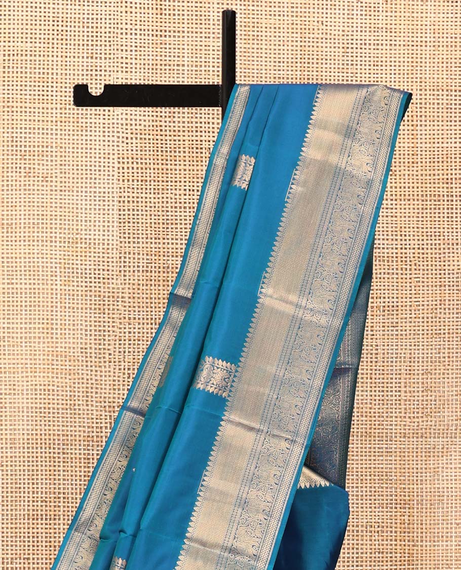 Blue Vasundhara Lite Silk Saree, Accentuated with Zari Buttas All Over Its Body, Highlighted by Zari Border of Thilakam, Mayil Kann, Kamalam, Rettai Neli, Yannai, and Vanki Designs, Delicately Woven Pallu and Paired with a Matching Blouse