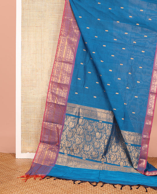 Blue Chettinad Cotton Saree Bedecked with Zari Buttas All Over Its Body, Complemented by Contrast Border Steeped with Traditional Zari Designs, Pallu of Floral and Peacock Designs, and Paired with a Matching Blouse