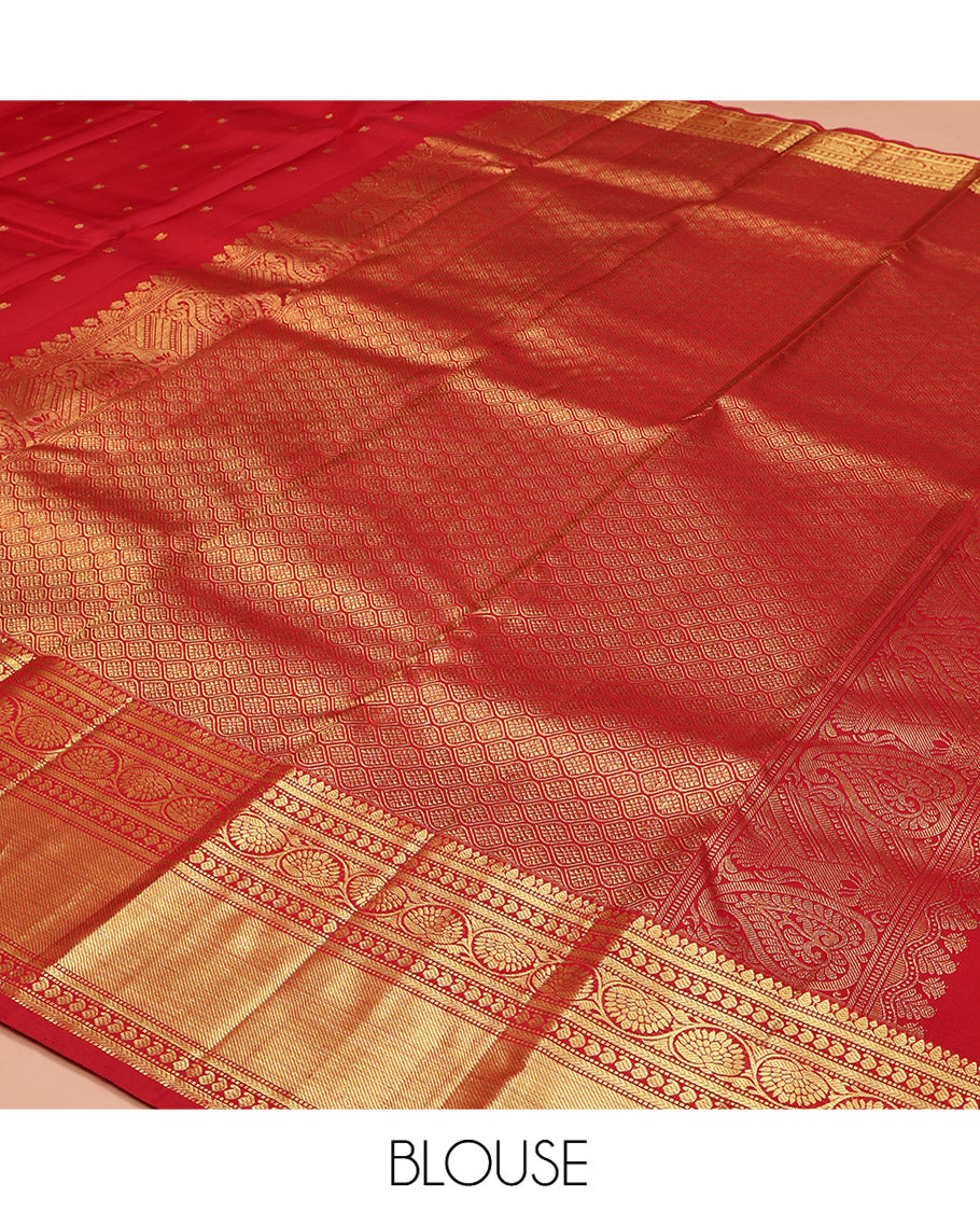 Red Kanchipuram Silk Saree, Subtly Sparkled with Zari Buttas All Over Its Body, Highlighted by a Zari Border of Thilakam, Kathir, Manga, and Dhavana Kodi Designs, Pallu of Jaal and Mayil Designs, and Paired with a Matching Blouse