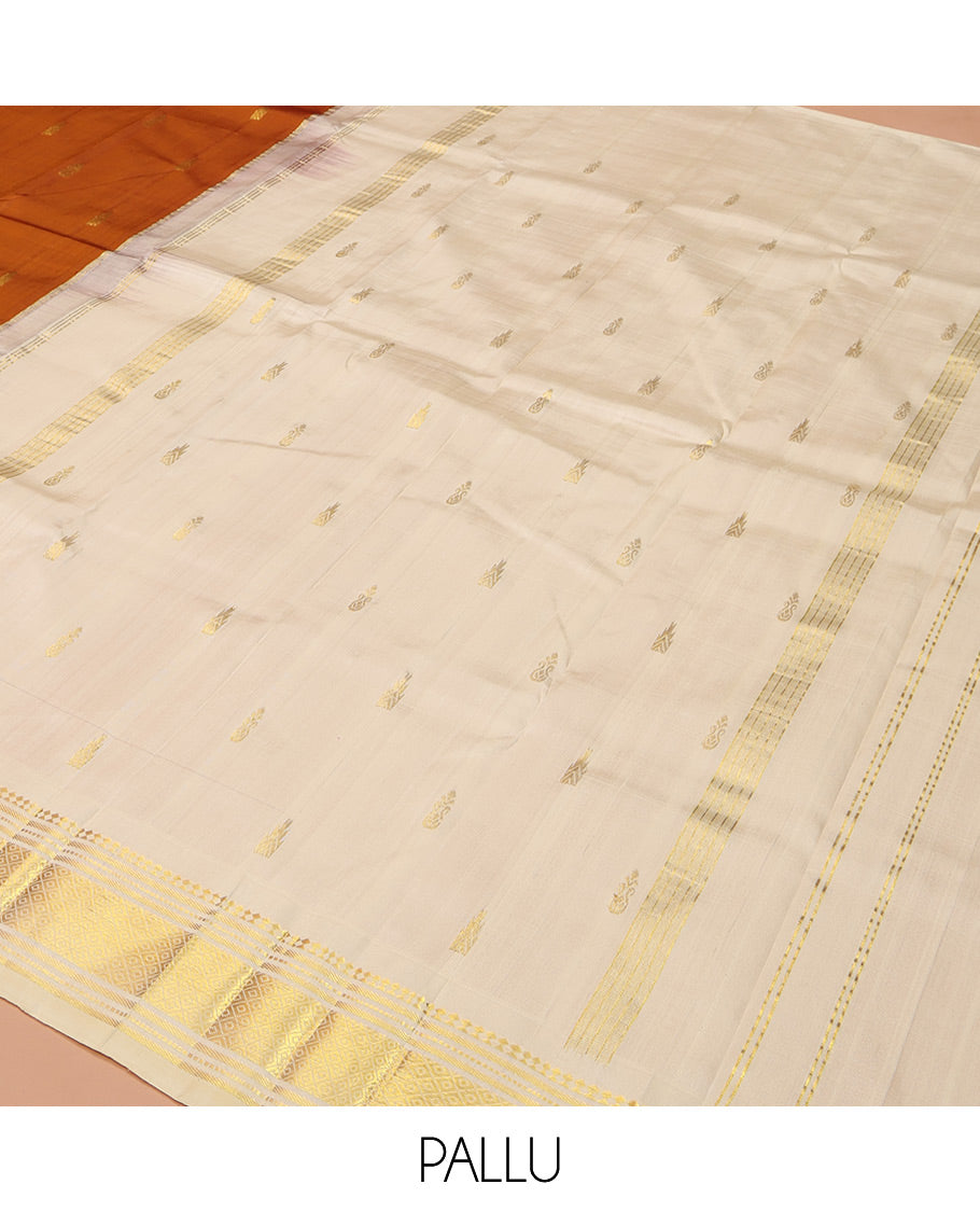 Rust Orange Kanchipuram Silk Saree, Bedecked with Zari Buttas on Its Body, Complemented by a Contrast One-Sided Border of Panner Sombu, Banaras, Muthu, and Mayil Kann Designs, Pallu of Zari Designs, and Comes Without a Blouse