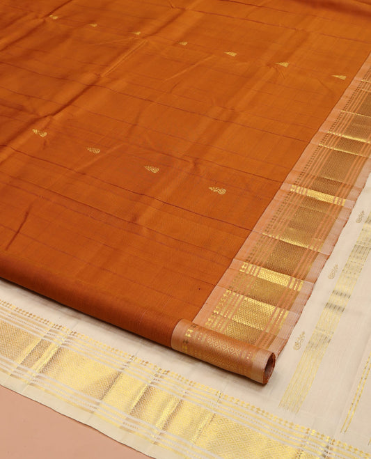 Rust Orange Kanchipuram Silk Saree, Bedecked with Zari Buttas on Its Body, Complemented by a Contrast One-Sided Border of Panner Sombu, Banaras, Muthu, and Mayil Kann Designs, Pallu of Zari Designs, and Comes Without a Blouse