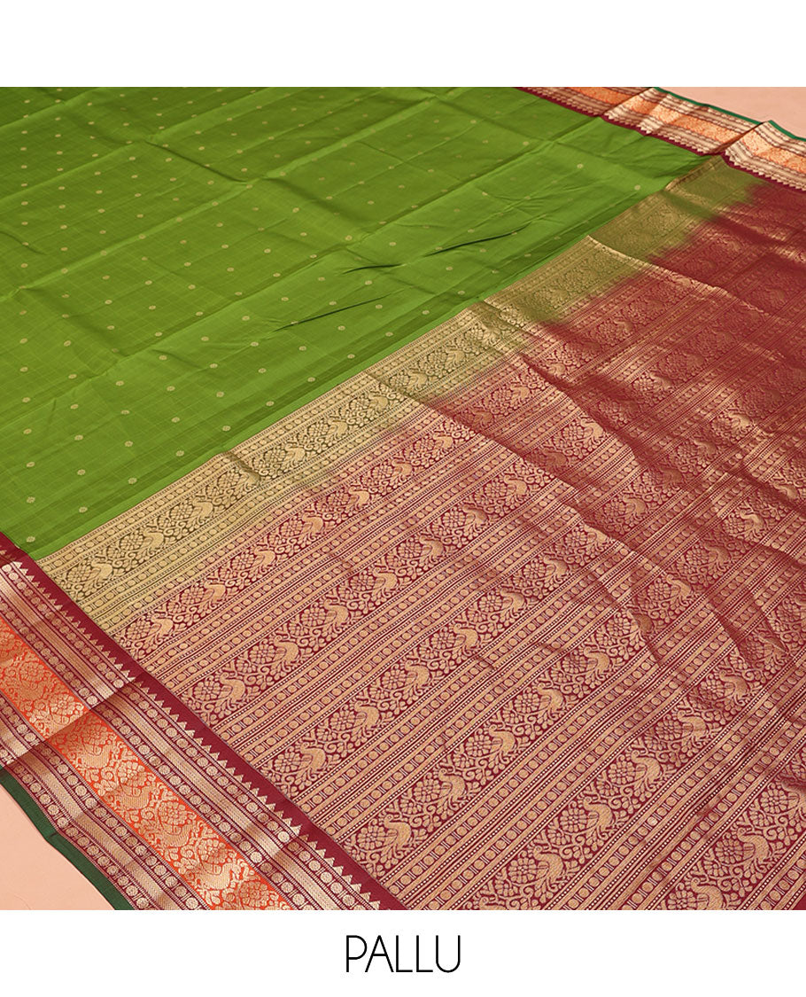 Green Vasundhara Silk Saree, Sparsely Woven with Zari Buttas All Over Its Body, Complemented by a Contrast Border of Rekku, Poun, Kathir, and Mayil Designs, Pallu Steeped with the Same Border Designs, and Paired with a Contrast Blouse