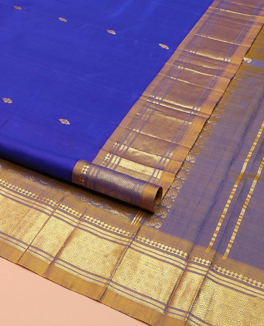 Blue Kanchipuram Silk Saree, Gleamed Up with Zari Buttas on Its Body, Complemented by a Contrast One-Sided Border of Paneer Sombu, Banaras, and Jaal Designs, Pallu of Floral Designs, and Comes Without a Blouse
