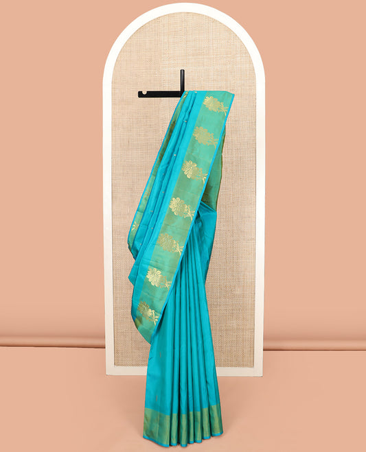 Blue Kanchipuram Silk Saree Subtly Sparkled with Zari Buttas, Complemented by a Contrast Border of Floral Zari Designs, Pallu Delicately Woven with Floral-Paisley Designs, and Paired with a Contrast Blouse