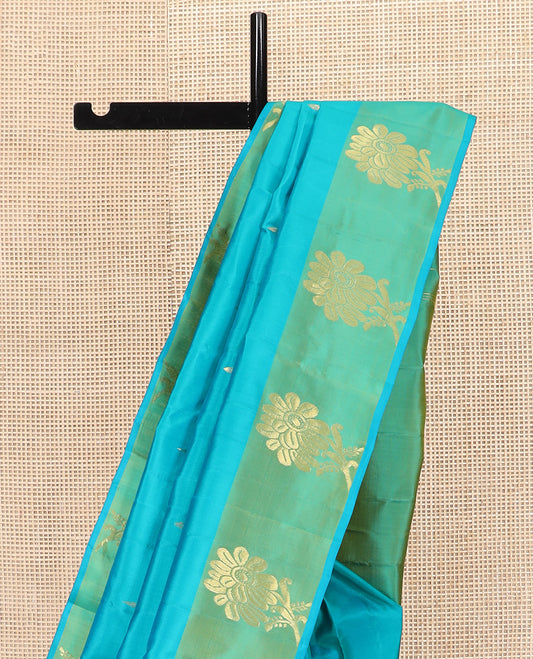 Blue Kanchipuram Silk Saree Subtly Sparkled with Zari Buttas, Complemented by a Contrast Border of Floral Zari Designs, Pallu Delicately Woven with Floral-Paisley Designs, and Paired with a Contrast Blouse