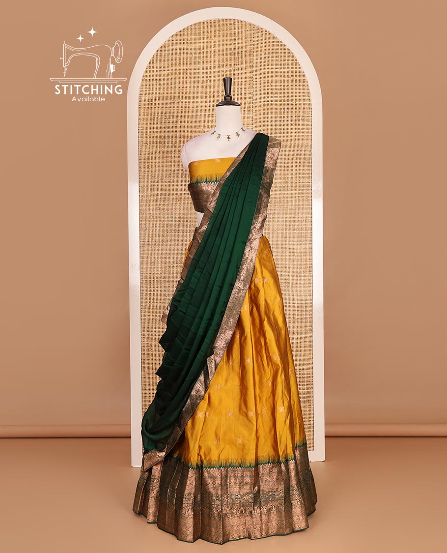 Mustard taffeta silk half saree, zari buttas with contrast green traditional zari border skirt, matching zari design blouse, and contrast plain zari border syska georgette dhavani