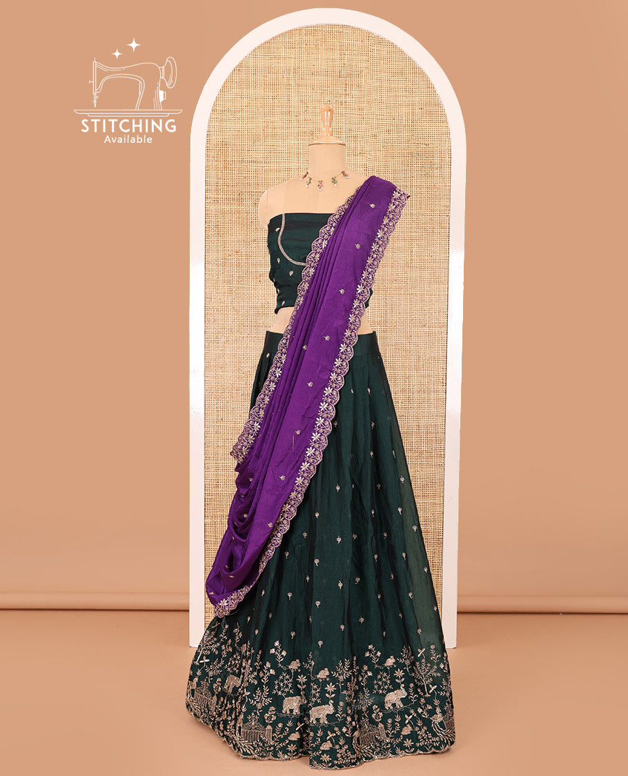 Bottle green half-saree, buttas and flora-fauna embroidered bordered velvet organza skirt, a matching velvet organza blouse, and a contrast embroidered scallop syska georgette dhavani