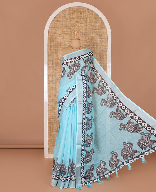 Blue plain linen cotton saree, silver zari border of elephant motifs print, elephant motifs pallu, and a contrast elephant motifs printed blouse