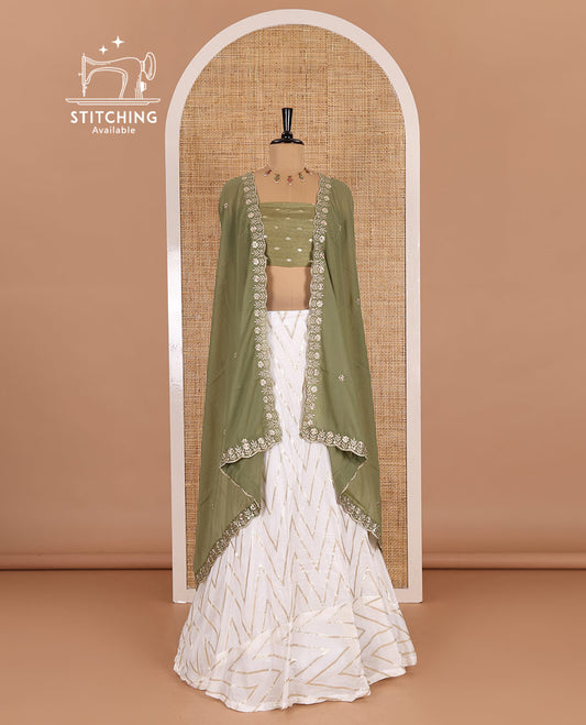 Cream-pista green half-saree, gold chevron striped nylon viscose crepe skirt, contrast diamond buttas blouse, and  a contrast scallop floral-theme embroidered dhavani