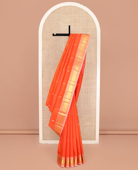 Orange Kanchipuram Silk Saree, Mesmerized with Zari Buttas on Its Body, Complemented by a Contrast One-Sided Border of Paneer Sombu, Banaras, Muthu and Mayil Kann Designs, Pallu of Zari Designs, and Comes Without a Blouse
