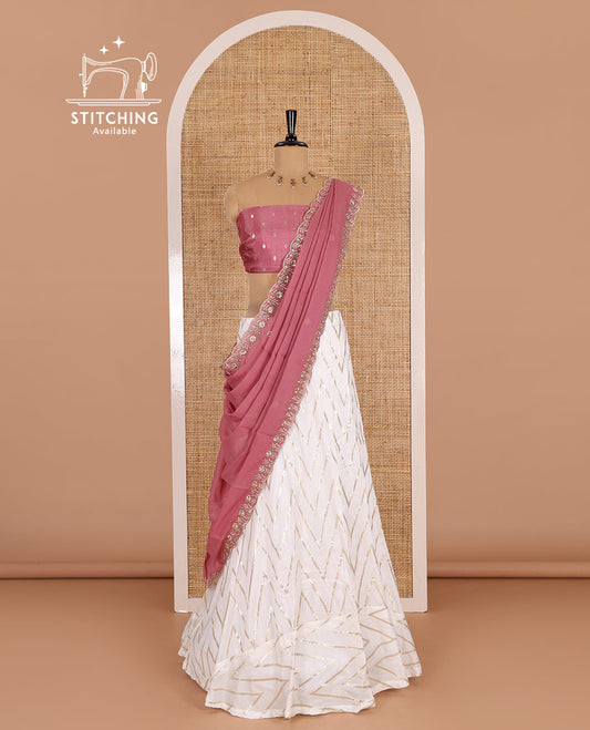 Cream-pink half-saree, gold chevron striped nylon viscose crepe skirt, contrast diamond buttas blouse, and  a contrast scallop floral-theme embroidered dhavani