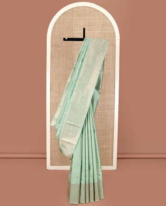 Green Kanchipuram Silk Saree, Delicately Woven with Zari Buttas All Over Its Body, Highlighted by a Zari Border of Floral and Paisley Designs, Grand Chevron Striped Pallu, and Paired with a Matching Blouse