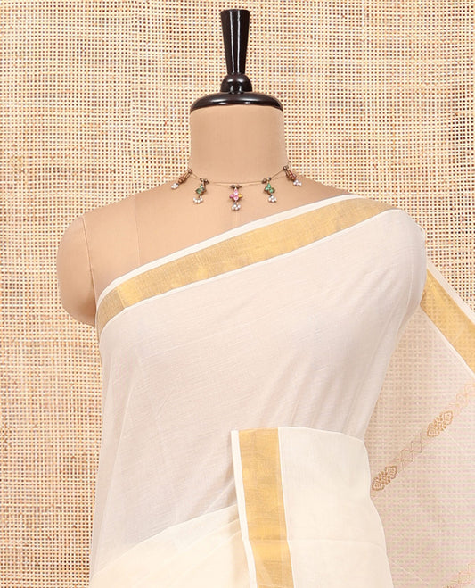 Cream Kerala Cotton Saree, Spotlighted with Zari Stripes All Over Its Body, a Subtle Bavanji Border, Pallu of Intricate Designs, and Is Paired with a Matching Blouse