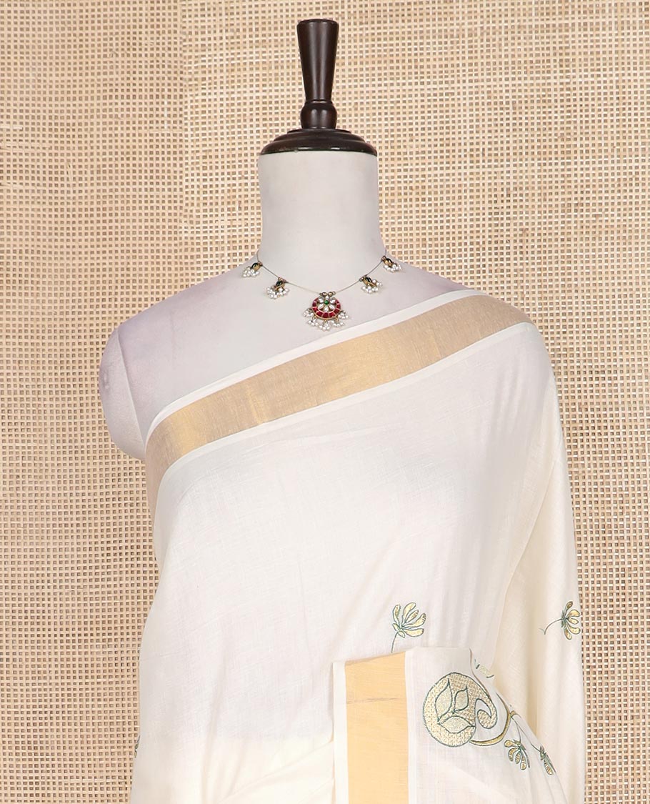 Cream paisley embroidered Kerala cotton saree, zari border, and paisley embroidered pallu