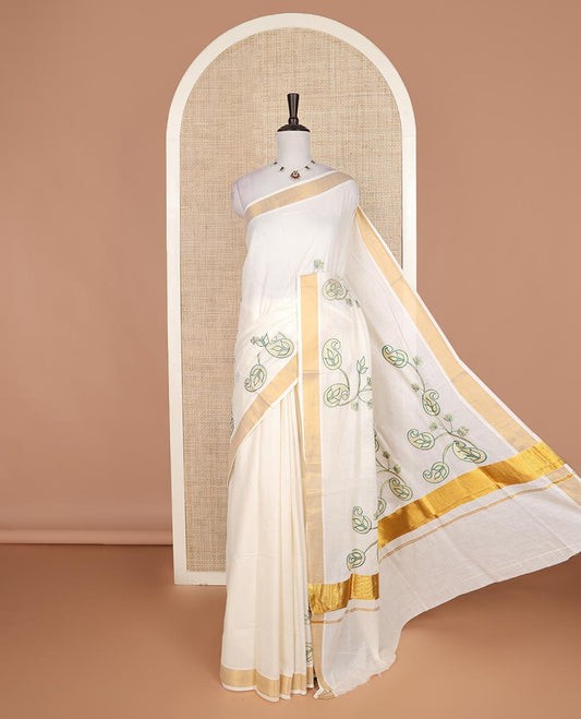 Cream paisley embroidered Kerala cotton saree, zari border, and paisley embroidered pallu
