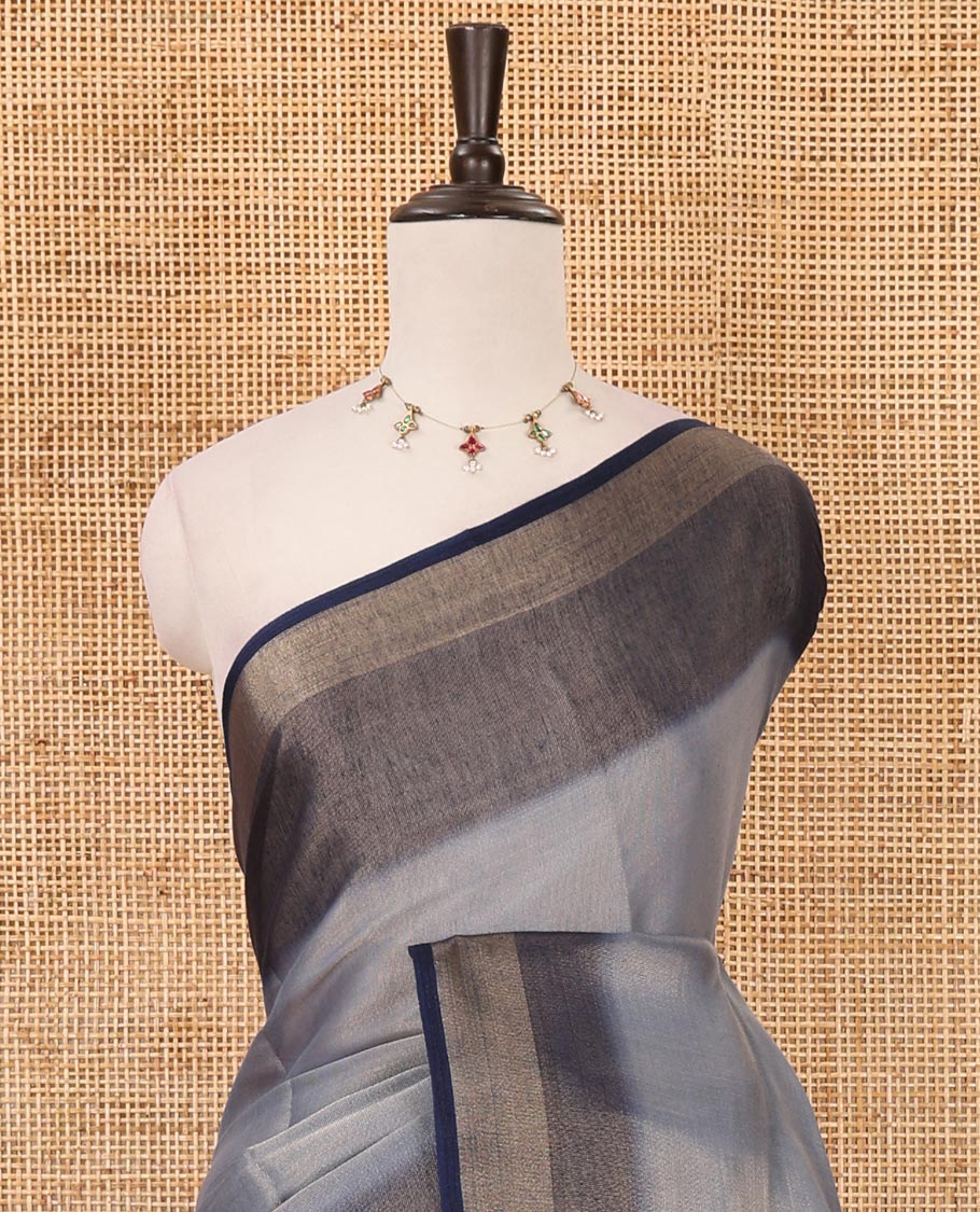 Grey plain tissue saree, contrast gold zari piping border & self pallu with tussels