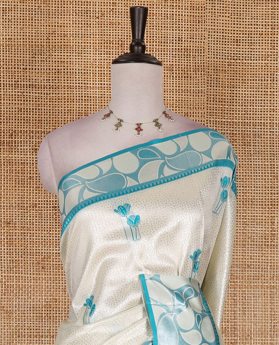 Half-white jacquard kanchi silk saree, contrast border, and pallu steeped with paisley motifs with contrast zari design blouse