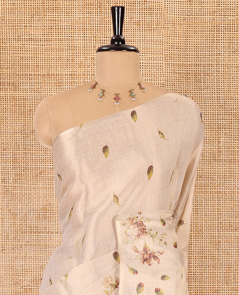Cream leaf and floral printed tissue saree with border and pallu of floral and leaf print, a small floral printed blouse