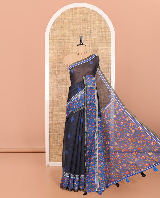 Black Linen Saree Adorned with Leaf Motifs All Over Its Body, Complemented by a Contrast Floral Vine Printed Border, Pallu Mirrors the Floral Vine Print, and Paired with a  Contrast Floral Printed Blouse