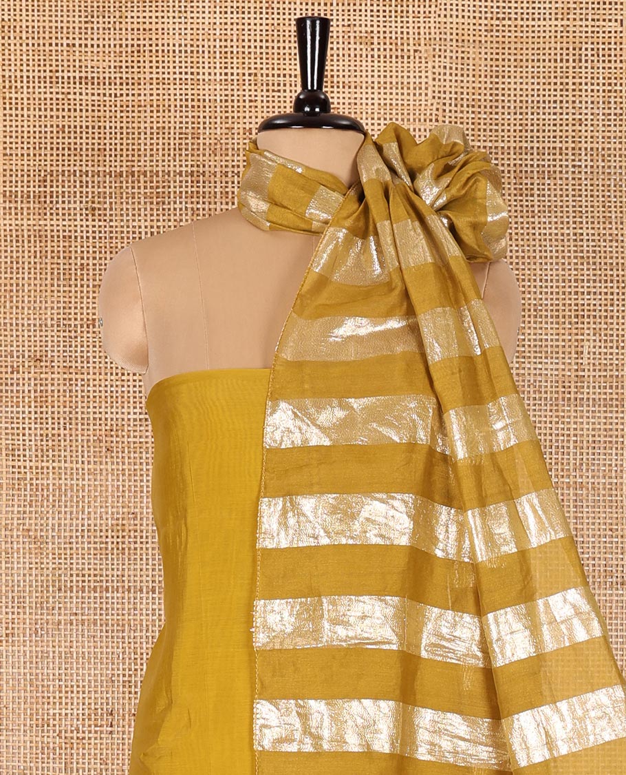 Mustard material chudidar set, plain with pom-pom tasseled mul chanderi top, a matching bottom, and organza dupatta of stripes